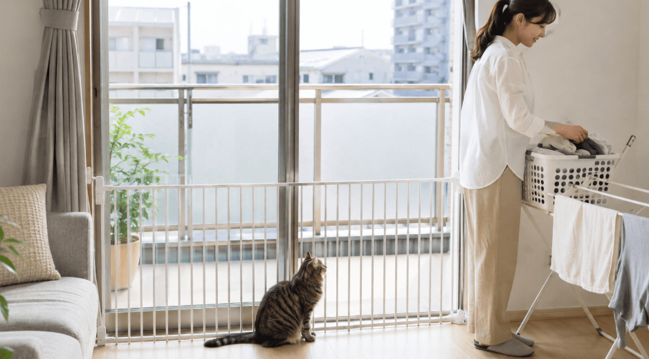 賃貸マンションのベランダ前に室内側ゲートを設置して猫の脱走を防ぐ様子
