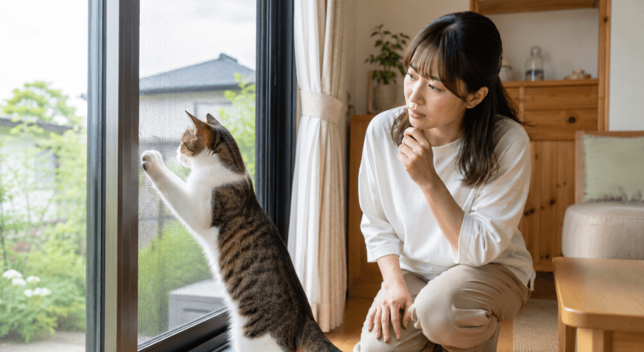 網戸に前足を掛ける猫を見守る女性と窓からの脱走対策